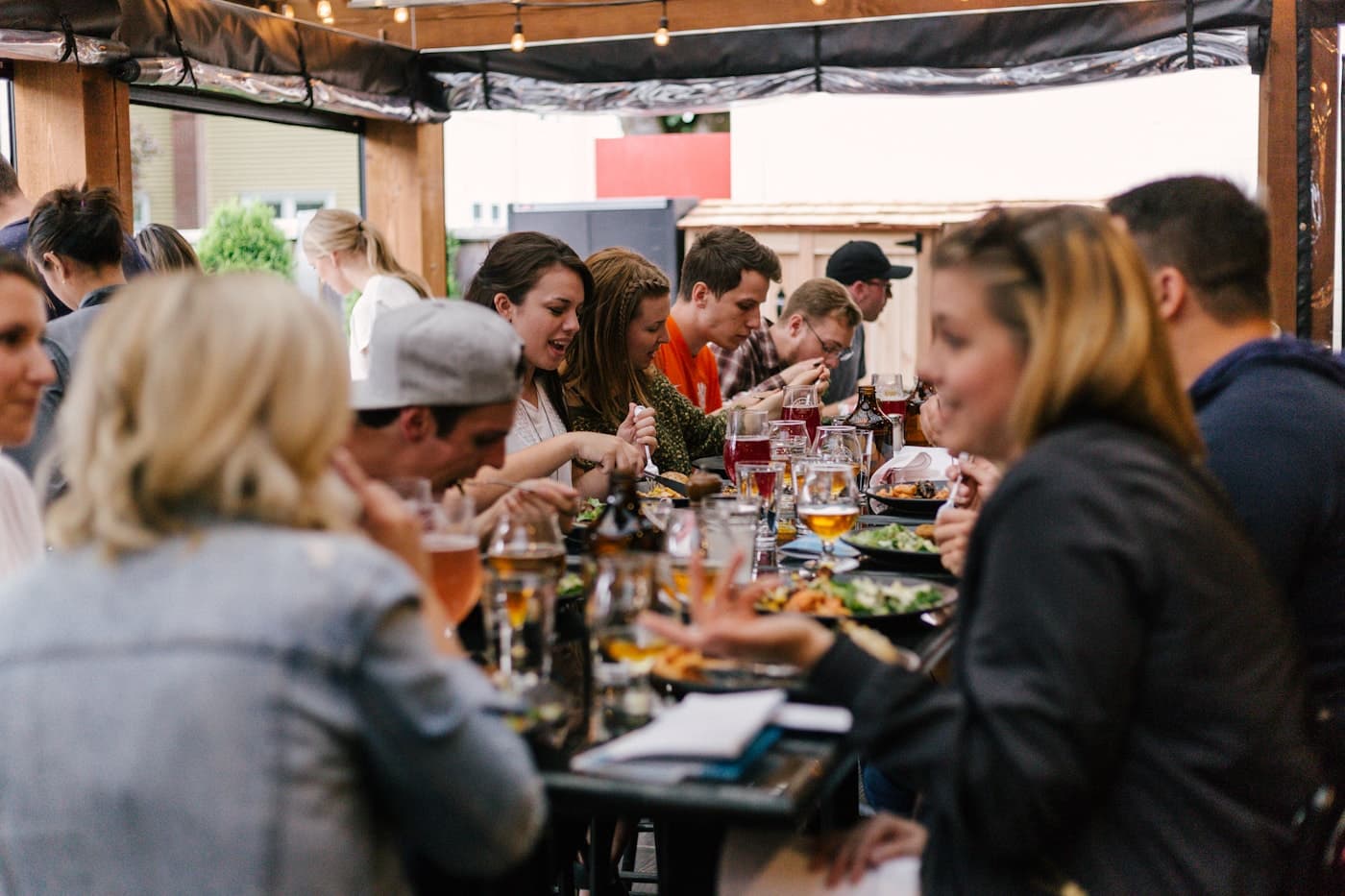 Happy friends eating and drinking together at a lively event.